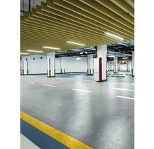 Photo d''intérieur d''un parking souterrain avec sol en béton, colonnes et revêtement de plafond.