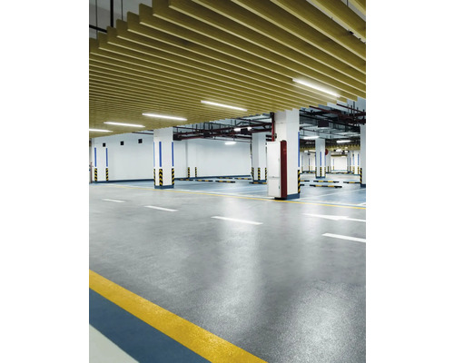 Photo d''intérieur d''un parking souterrain avec sol en béton, colonnes et revêtement de plafond.