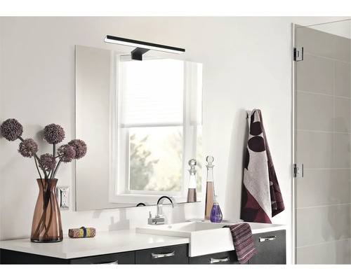 Salle de bain moderne avec lavabo, miroir, lampe et décorations.