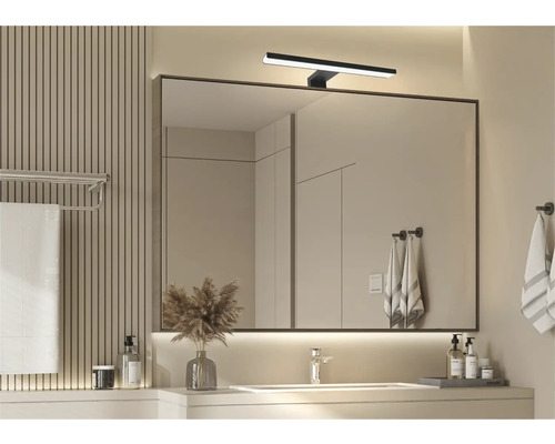Salle de bain moderne avec miroir, lavabo et éclairage pour une atmosphère lumineuse et organisée.