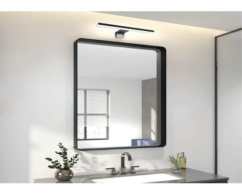 Salle de bains moderne avec miroir, lavabo et lampe