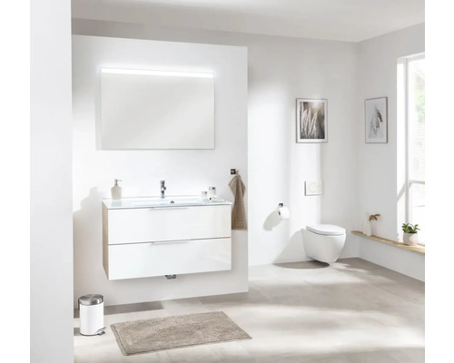 Salle de bains lumineuse avec meuble-lavabo, miroir et WC suspendu pour un aménagement moderne.