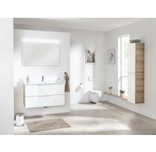 Helles Badezimmer mit Waschtisch, Spiegel mit Beleuchtung, Toilette und Hochschrank.