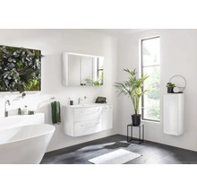 Salle de bains lumineuse avec baignoire, meuble-lavabo, armoire de toilette et étagère murale
