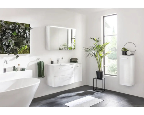 Salle de bains lumineuse avec baignoire, meuble-lavabo, armoire de toilette et étagère murale