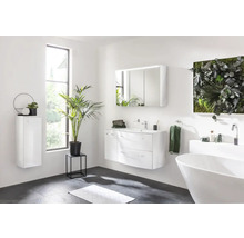 Salle de bain lumineuse avec lavabo, miroir, baignoire et plantes
