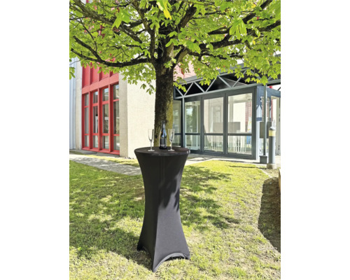 Stehtisch mit Hülle, Sektflasche und zwei Gläsern im Freien