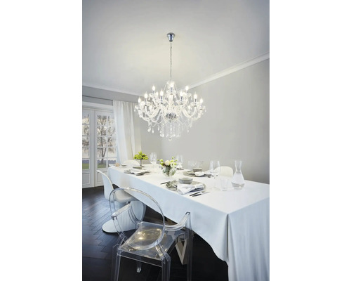 Esstisch mit Geschirr und Kristalllüster in einem hellen Raum