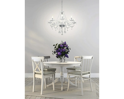 Esszimmer mit rundem Tisch, Stühlen, Blumen und Kristalllüster.