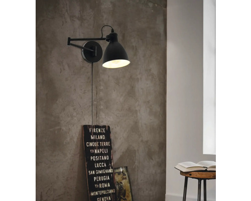 Schwenkbare Wandleuchte in einem Raum mit einem Buch auf einem Hocker.