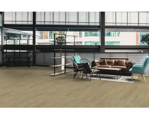 Pièce lumineuse avec plancher en bois, canapé, fauteuil et étagères.