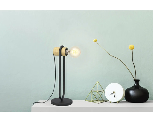 Dekorative Tischleuchte aus Holz und Metall auf einem Tisch