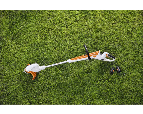 Coupe-bordures à batterie avec deux batteries sur la pelouse