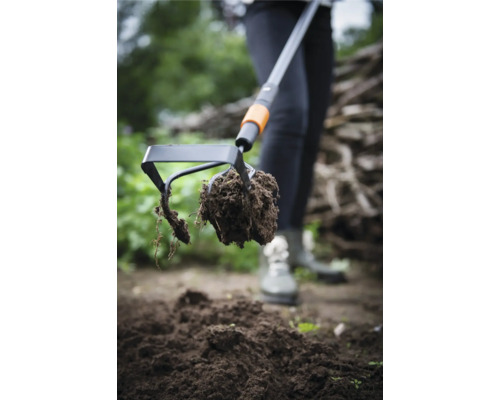 Gartenhacke mit Erdklumpen im Einsatz