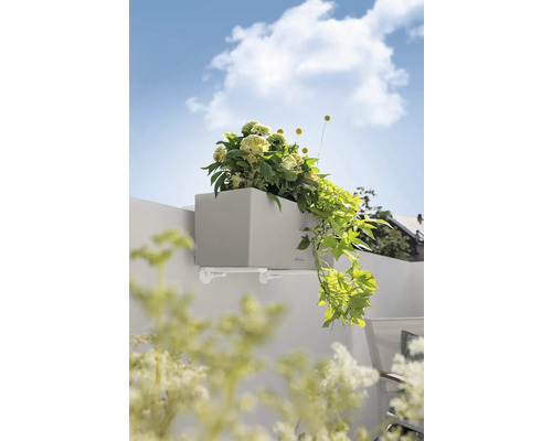 Jardinière grise avec support et plantations sur un mur.