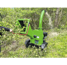 Broyeur de branches au travail pour broyer les branches et les brindilles dans le jardin.