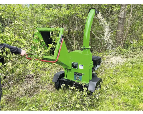 Broyeur de branches au travail pour broyer les branches et les brindilles dans le jardin.