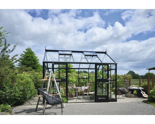 Serre de jardin avec plantes, meubles et outils de jardinage.