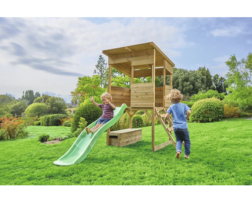 Toboggan pour enfants et cabane en bois dans le jardin avec deux enfants