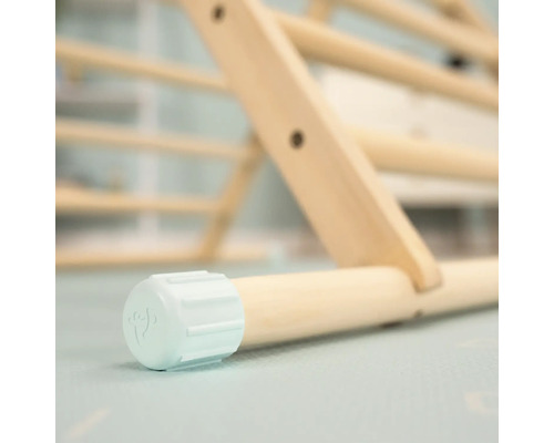 Gros plan sur un triangle d''escalade en bois avec un pied de couleur claire