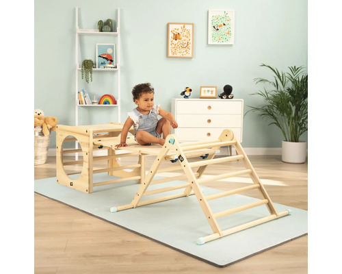 Un bambin est assis sur un portique d''escalade en bois dans une chambre d''enfant.