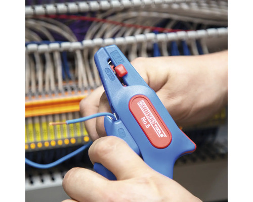 Eine Person verwendet eine automatische Abisolierzange zum Abisolieren eines blauen Kabels.