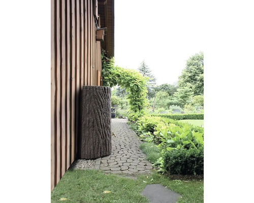 Jardin avec récupérateur d''eau de pluie aspect tronc d''arbre à côté d''une maison