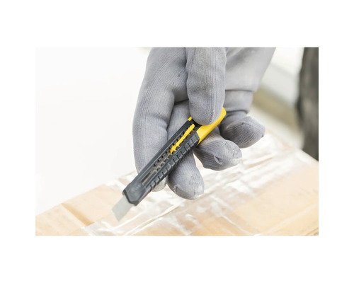 Hand mit Handschuh schneidet Klebeband auf einem Karton mit einem Cutter