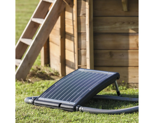 Chauffage de piscine solaire sur gazon avec échelle en arrière-plan