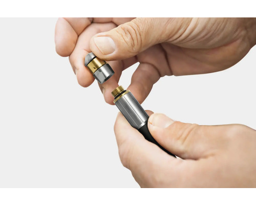 Deux mains vissent une buse sur un tuyau.