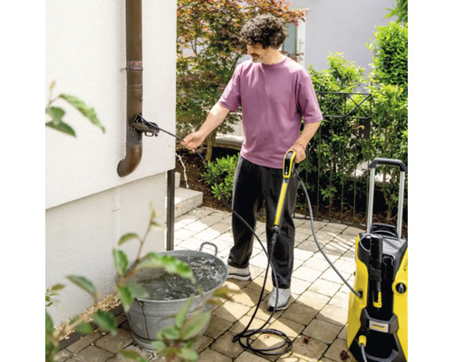 Un homme nettoie une gouttière avec un nettoyeur haute pression Kärcher