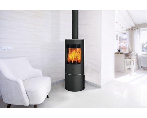 Intérieur moderne avec poêle à bois noir, fauteuil blanc et décoration claire