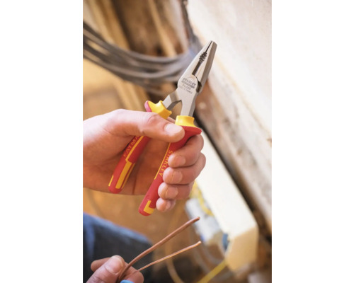 Eine Hand hält eine Kombizange der Marke Stanley zum Schneiden von Drähten.