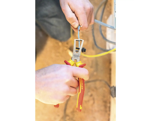 Eine Person verwendet eine Abisolierzange zum Abisolieren eines Kabels.