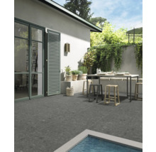 Terrasse avec table de jardin et chaises, carrelée avec des carreaux en grès cérame gris.