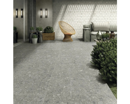 Aussenbereich mit grauen Bodenfliesen, Rattan-Sessel und Sitzgelegenheiten