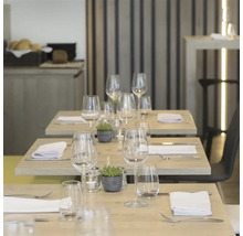 Tables dressées avec verres, couverts et serviettes dans un restaurant