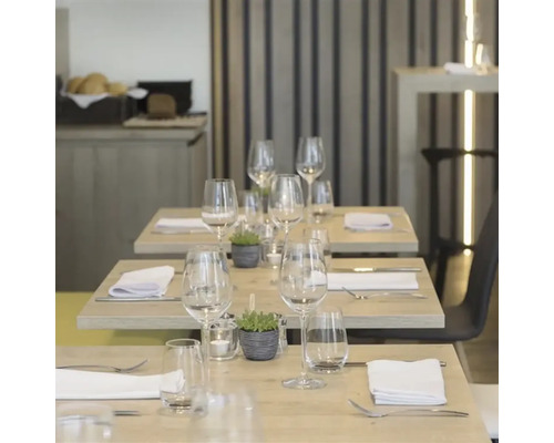 Tables dressées avec verres, couverts et décoration dans un restaurant