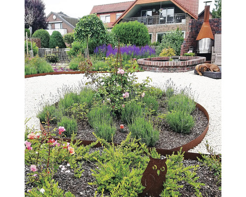 Jardin aménagé avec allées en gravier, parterres de fleurs avec rosiers et lavande, décoration de jardin et fontaine en brique