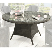 Table de jardin en rotin avec plateau en verre sur une terrasse
