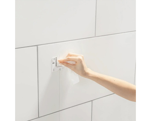 Montagevorrichtung an einer gefliesten Wand mit einer Hand, die sie reinigt