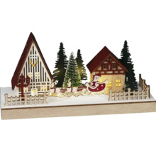 Dekorative Weihnachtslandschaft mit Häusern, Tannenbäumen, Rentieren und Weihnachtsmann im Schlitten