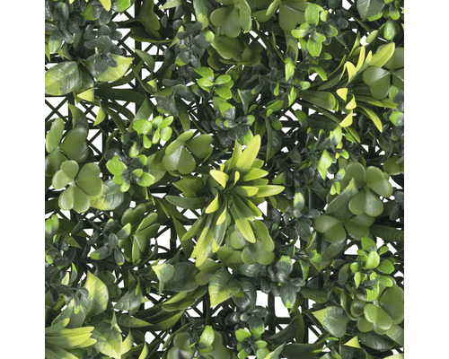 Künstliche Hecke mit verschiedenen grünen Blättern auf Kunststoffgitter
