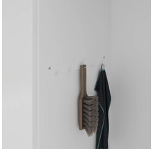 Porte-manteau mural avec brosse et serviette sur un mur blanc