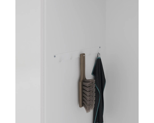Porte-manteau mural avec brosse et serviette sur un mur blanc