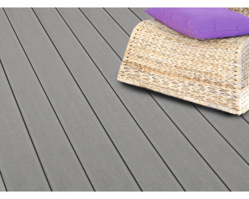 Graue Terrassendielen mit einem Korbsessel und Kissen