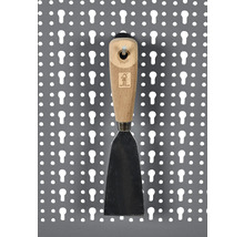 Spachtel mit Holzgriff an einer Lochwand