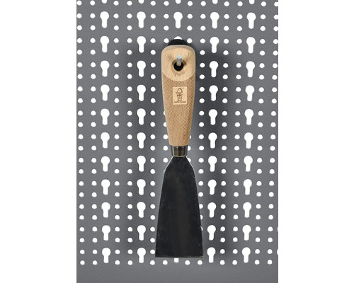 Spatule avec manche en bois sur un panneau perforé