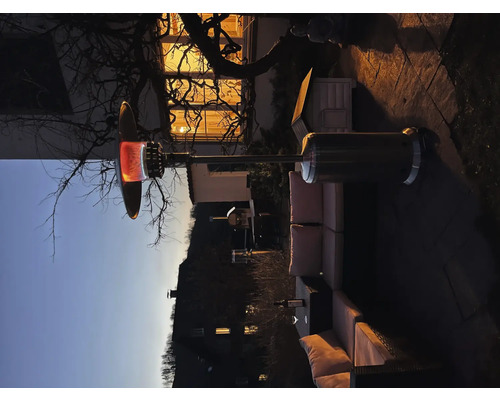 Scène de terrasse avec radiateur de terrasse et groupe de sièges pour l''extérieur le soir.