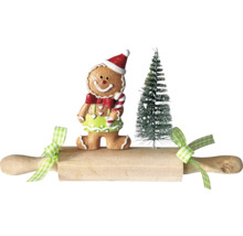 Scène décorative avec un bonhomme en pain d’épices, un sapin miniature et un rouleau à pâtisserie